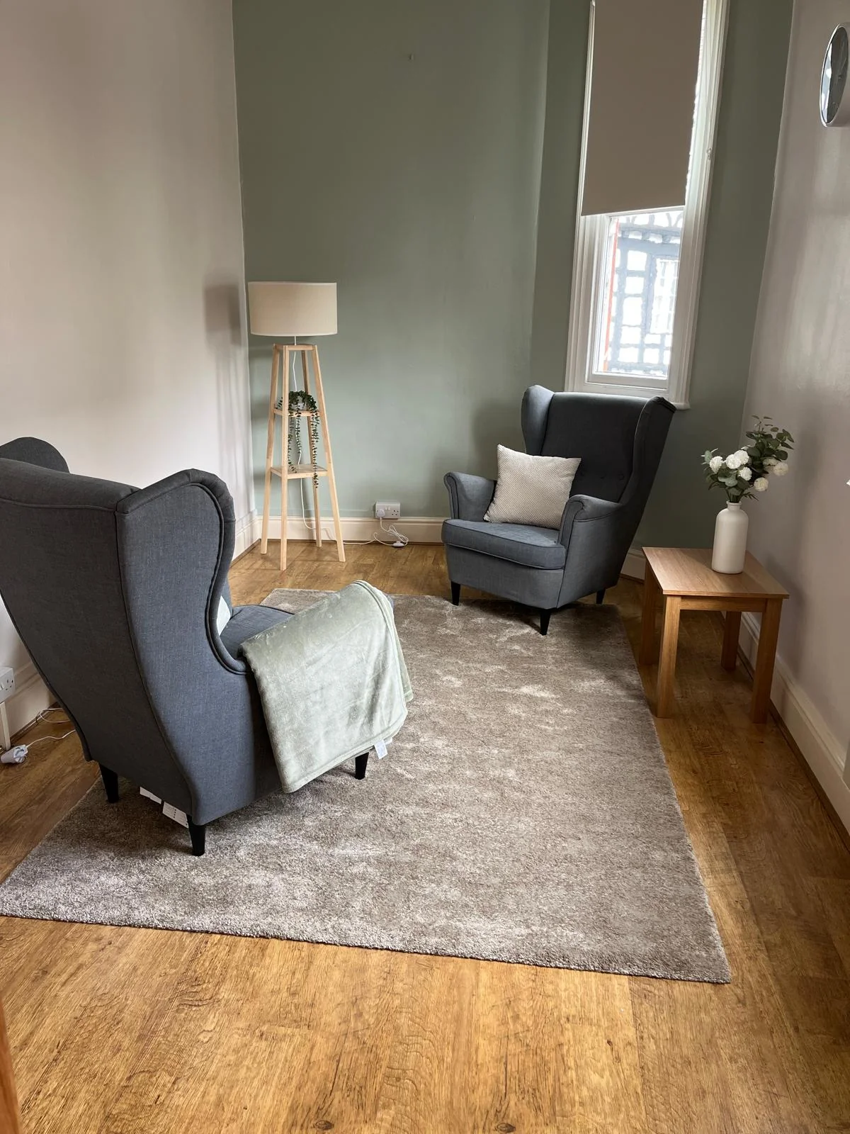 Two comfortable armchairs in a sage and neutral Calm Collective therapy room