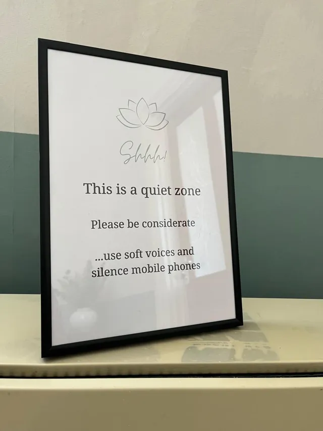 Framed Calm Collective sign asking visitors to use soft voices and silence mobile phones